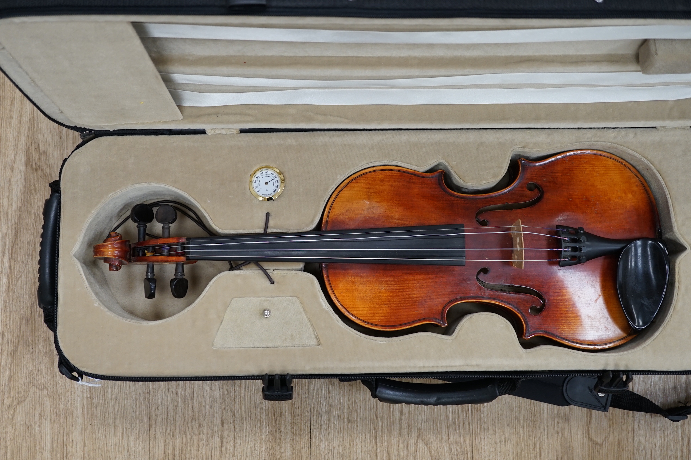 A Czechoslovakian student’s violin with Stradivarius label inside the body, length of body, 35.5cm, in a good modern case with fitted hygrometer